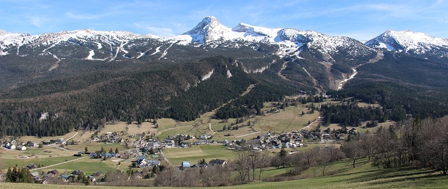 Vue panoramique du village de Saint-Martin-en-Vercors et du massif du Vercors, capturée dans le cadre des opérations de Mountain Wilderness visant à préserver et restaurer les paysages de montagne, notamment par le démontage d’installations obsolètes