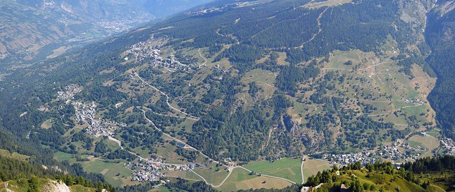 Vue aérienne de la vallée de la Tarentaise, en Savoie, offrant un panorama sur des villages alpins, des alpages verdoyants et des forêts par Vincent Bergerat.