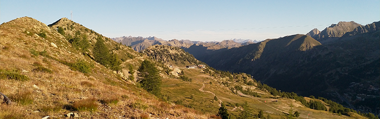 Cette image capture un paysage spectaculaire du Parc national du Mercantour, dans les Alpes-Maritimes, offrant une vue sur une crête montagneuse entre le vallon de Mollières et Isola 2000. On y aperçoit des sentiers serpentant à travers des prairies alpines, avec en arrière-plan la chaîne des Alpes. Ce site naturel, marqué par l’histoire militaire avec d’anciennes fortifications du Mur Alpin, témoigne du passé stratégique de la région. Un lieu idéal pour la randonnée, l’observation de la faune et la découverte du patrimoine alpin.